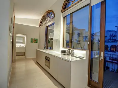 a kitchen with a sink and a large window at En Vogue by Hello Homes Sitges in Sitges