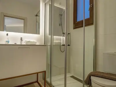 a bathroom with a glass shower and a toilet at En Vogue by Hello Homes Sitges in Sitges