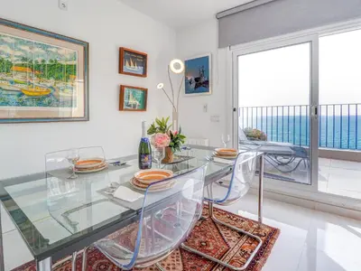a dining room with a glass table and chairs at Marina Duplex by Hello Homes Sitges in Sitges