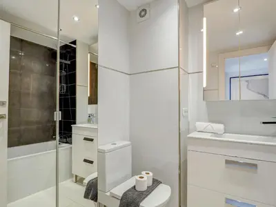 a white bathroom with a toilet and a shower at Marina Duplex by Hello Homes Sitges in Sitges