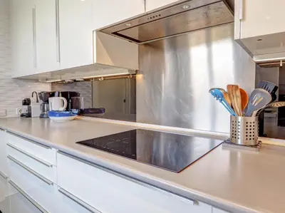 a kitchen with white cabinets and a counter top at Marina Duplex by Hello Homes Sitges in Sitges