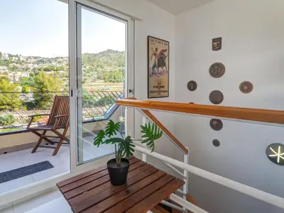 a staircase with a wooden table and a potted plant at Marina Duplex by Hello Homes Sitges in Sitges