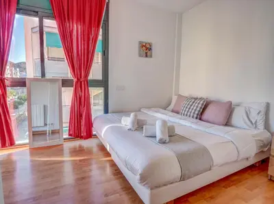 a white bed in a room with red curtains at Mimosa Apartment by Hello Homes Sitges in Sitges