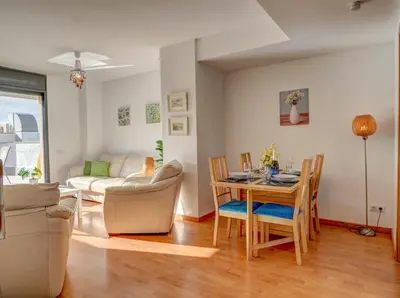 a dining room and living room with a table and chairs at Mimosa Apartment by Hello Homes Sitges in Sitges
