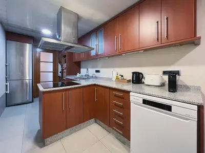 a kitchen with wooden cabinets and white appliances at Stay U-nique Apartments Diagonal in Barcelona