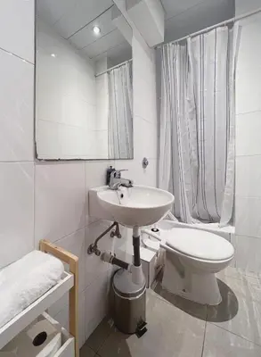 a white bathroom with a sink and a toilet at Stay U-nique Apartments Diagonal in Barcelona