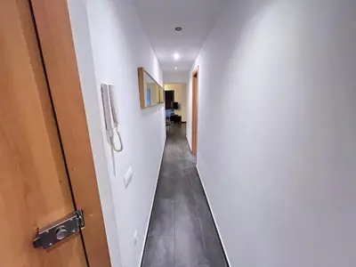 a hallway with a white wall and a door at GORGEOUS APARTMENT IN DOWNTOWN in Barcelona