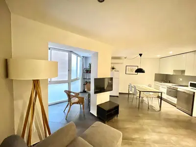 a living room and kitchen with a table and chairs at GORGEOUS APARTMENT IN DOWNTOWN in Barcelona