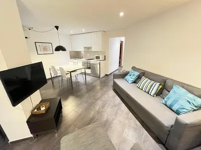 a living room with a couch and a kitchen at GORGEOUS APARTMENT IN DOWNTOWN in Barcelona
