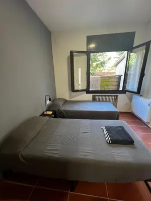 a bedroom with two beds and a window at ALOJAMIENTO CON JARDIN 20KM BARCELONA in Vilassar de Dalt
