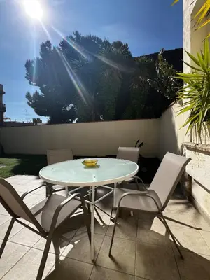 a white table and chairs on a patio at ALOJAMIENTO CON JARDIN 20KM BARCELONA in Vilassar de Dalt