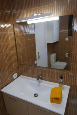 a bathroom with a sink with a yellow towel on it at ALOJAMIENTO CON JARDIN 20KM BARCELONA in Vilassar de Dalt