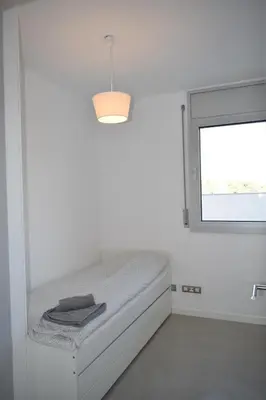 a white room with a bed and a window at Magnificent apartment close to the beach in Barcelona