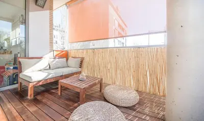 a living room with a couch and a table on a balcony at Magnificent apartment close to the beach in Barcelona