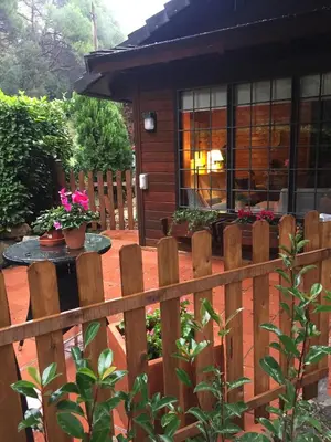 a wooden fence in front of a house with flowers at Caseta de Fusta in Aiguafreda