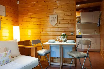 a small kitchen with a table and chairs in a room at Caseta de Fusta in Aiguafreda