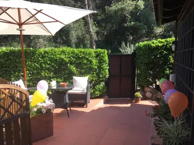 a patio with an umbrella and a chair and a table at Caseta de Fusta in Aiguafreda