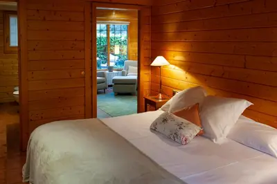 a bedroom with a bed and a living room at Caseta de Fusta in Aiguafreda