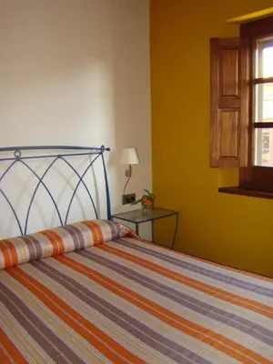 a bedroom with a bed and a table with a window at Can Vilafort in Collsuspina