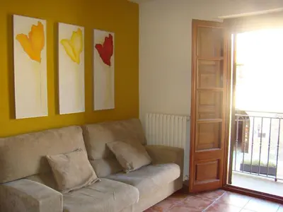 a living room with a couch and some pictures on the wall at Can Vilafort in Collsuspina