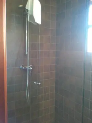 a bathroom with a shower with a glass door at Can Vilafort in Collsuspina