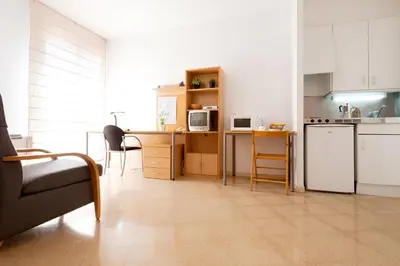 a kitchen with a refrigerator and a table with chairs at Residencia Universitaria Resa Francesc Giralt i Serrà in Terrassa