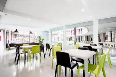 a dining room with tables and chairs and windows at Residencia Universitaria Resa Francesc Giralt i Serrà in Terrassa