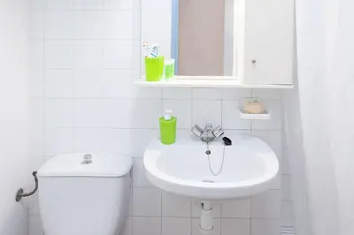 a white bathroom with a toilet and a sink at Residencia Universitaria Resa Francesc Giralt i Serrà in Terrassa
