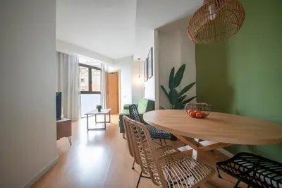 a dining room with a wooden table and chairs at You Stylish Sagrada Familia Apartments in Barcelona
