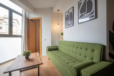 a living room with a green couch and a table at You Stylish Sagrada Familia Apartments in Barcelona