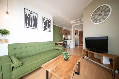 a living room with a green couch and a tv at You Stylish Sagrada Familia Apartments in Barcelona