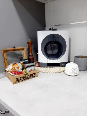 a microwave sitting on a kitchen counter with a box of food at Nur Apartment in Terrassa