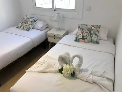 a room with two beds with a bouquet of flowers at Vilamarlux IV in Vilassar de Mar