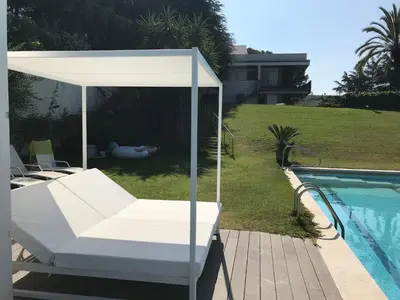 a white canopy bed next to a swimming pool at Casa Vila Reyes in Sant Vicenç de Montalt