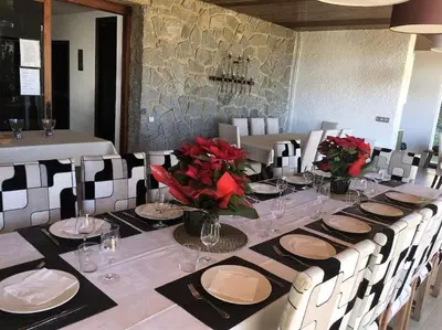 a dining room with a long table with red flowers at Casa Vila Reyes in Sant Vicenç de Montalt