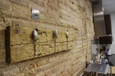 a brick wall with three hooks on it at Mr. Serrano Apartments in Barcelona