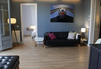 a living room with a black couch and a blue wall at Mr. Serrano Apartments in Barcelona