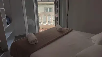 a bedroom with a bed and a window with a balcony at Chopin Magic Fountain in Barcelona