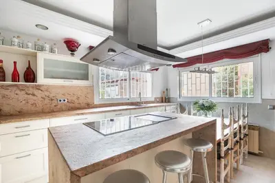 a kitchen with a large counter with stools in it at TOWANDA HOUSE in Sant Just Desvern