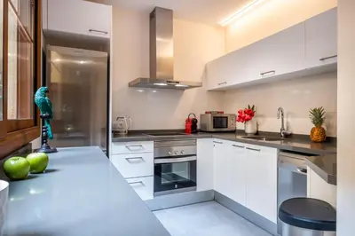 a kitchen with white cabinets and stainless steel appliances at Lux Apartments Barcelona in Barcelona