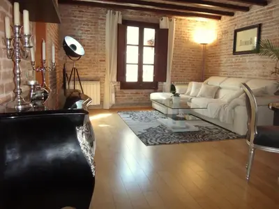 a living room with a white couch and a brick wall at Lux Apartments Barcelona in Barcelona