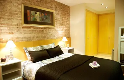a bedroom with a large black bed and two tables at Lux Apartments Barcelona in Barcelona