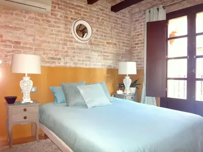 a bedroom with a blue bed and a brick wall at Lux Apartments Barcelona in Barcelona