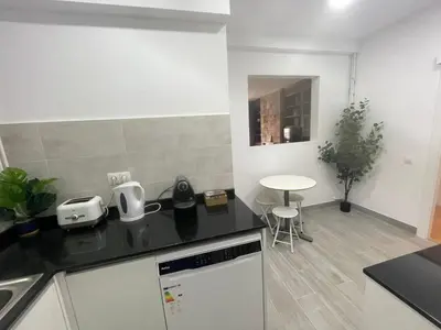 a kitchen with a black counter top and a table at Family-Friendly Home in Central Barcelona 4BDR in Barcelona