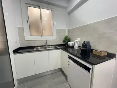 a small kitchen with white cabinets and a sink at Family-Friendly Home in Central Barcelona 4BDR in Barcelona