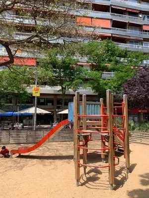 a playground with an orange slide in the sand at Family-Friendly Home in Central Barcelona 4BDR in Barcelona