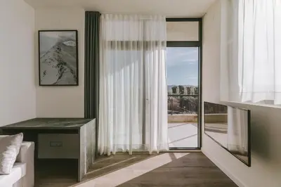 a living room with a large window and a desk at CIM Aparthotel in Sant Cugat del Vallès