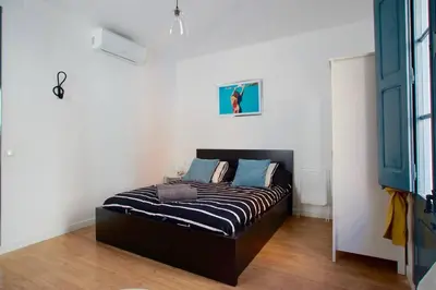 a bedroom with a bed with blue pillows on it at LOVELY FLAT FIRA MWC in Hospitalet de Llobregat