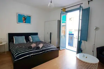 a bedroom with a bed with two people laying on it at LOVELY FLAT FIRA MWC in Hospitalet de Llobregat