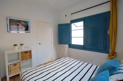 a bedroom with a bed and a blue window at LOVELY FLAT FIRA MWC in Hospitalet de Llobregat